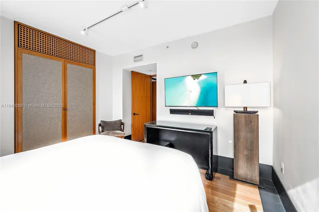 a bedroom with a bed and a flat screen tv