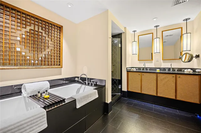 a bathroom with a granite countertop sink and a bathtub