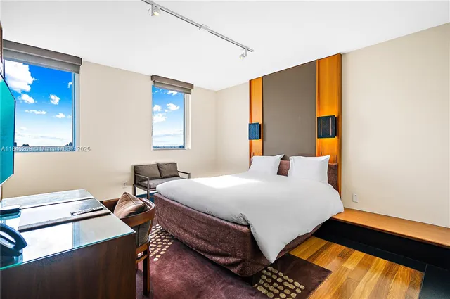 a bedroom with a bed and a lamp on the dresser