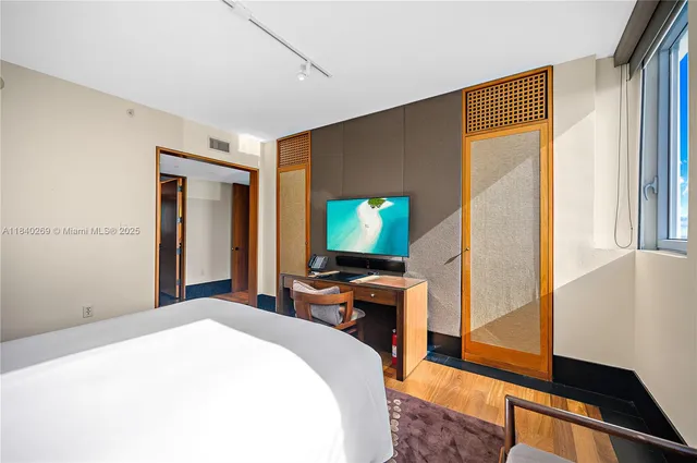 a bedroom with a bed and wooden floor