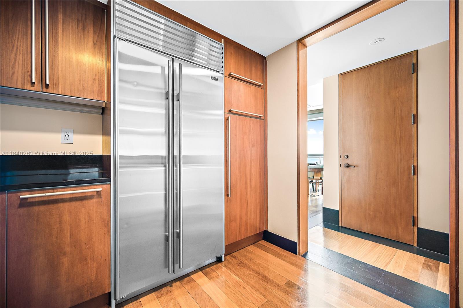 101 20th Street, Unit 3504 Miami Beach, FL 33139 - Photo 24 of 25 a view of a refrigerator in kitchen and an empty room with wooden floor