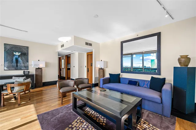 a living room with furniture wooden floor and a window