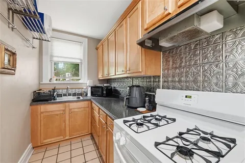 a kitchen with granite countertop a stove sink and cabinets