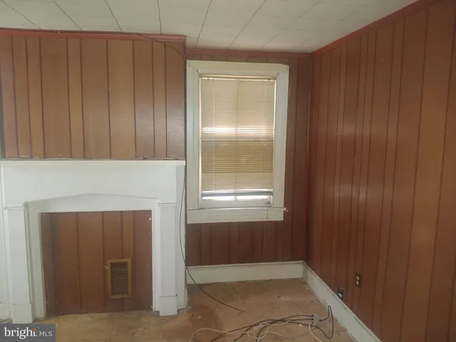 an empty room with windows and a fireplace