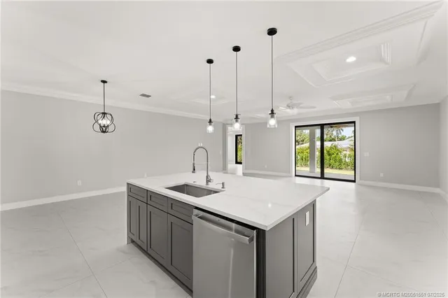 a kitchen with a sink a chandelier and living room view