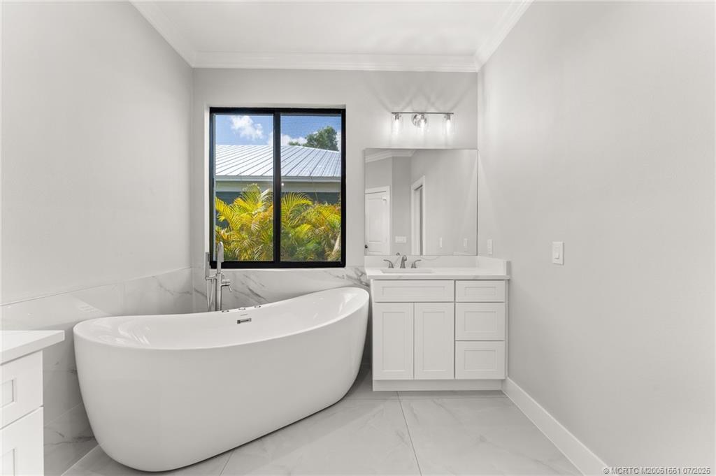 5460 Southeast Front Avenue Stuart, FL 34997 - Photo 25 of 40 a bathroom with a bathtub and window