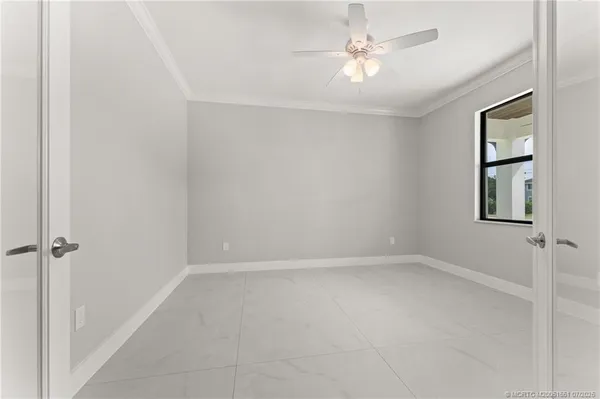 an empty room with windows and fan