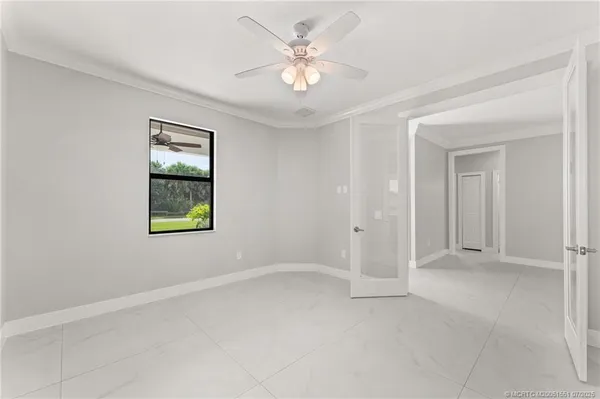 an empty room with windows and fan
