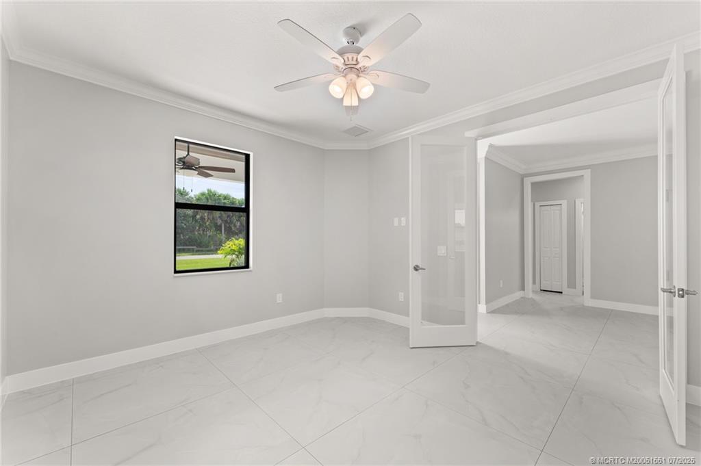 5460 Southeast Front Avenue Stuart, FL 34997 - Photo 27 of 40 an empty room with windows and fan