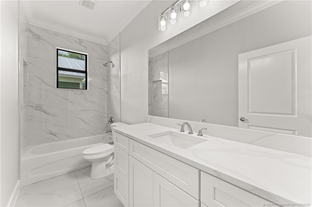 5460 Southeast Front Avenue Stuart, FL 34997 - Photo 32 of 40 a bathroom with a sink a toilet and shower