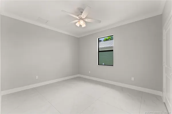 an empty room with a window and a ceiling fan