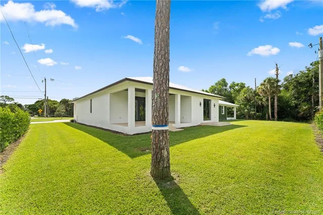 a front view of house with yard and swimming pool