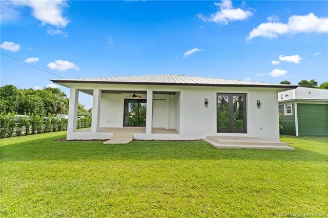 a view of a house with a yard and potted plants