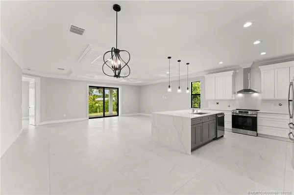 a large kitchen with stainless steel appliances granite countertop a stove a sink a refrigerator and a window