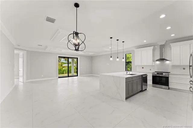 a large kitchen with stainless steel appliances granite countertop a stove a sink a refrigerator and a window