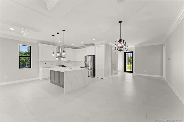 a large white kitchen with a window and stainless steel appliances