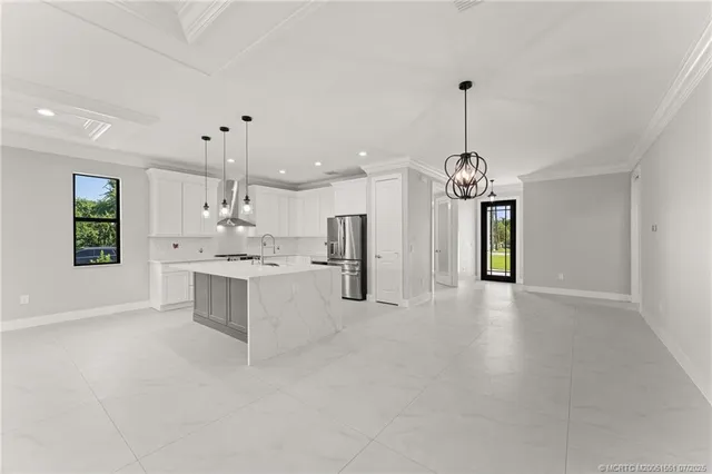 a large white kitchen with a window and stainless steel appliances