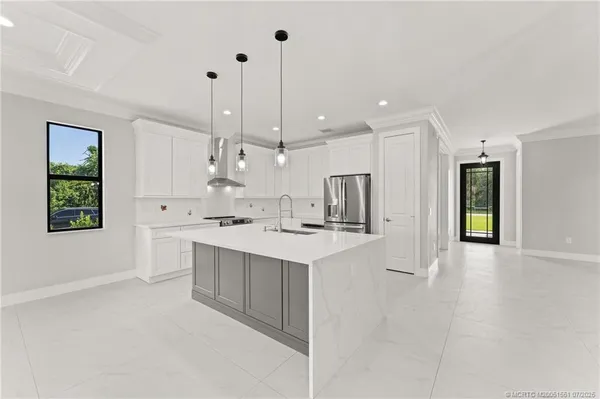 a kitchen with kitchen island a sink stainless steel appliances and cabinets