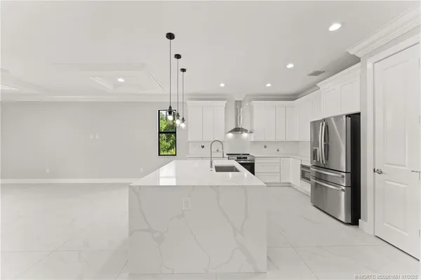 a kitchen with stainless steel appliances a refrigerator sink and stove