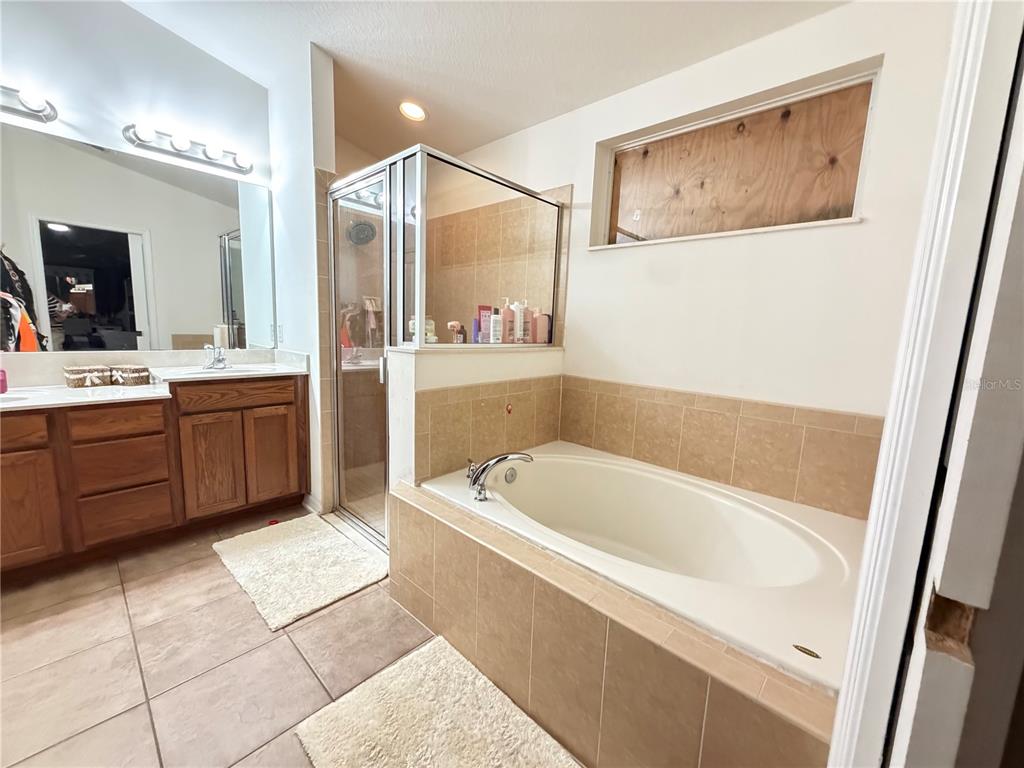 945 Tramells Trail Kissimmee, FL 34744 - Photo 24 of 36 a bathroom with a tub a sink and mirror