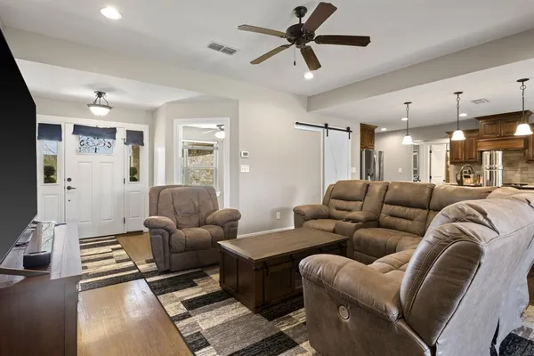 a living room with furniture and a view of kitchen