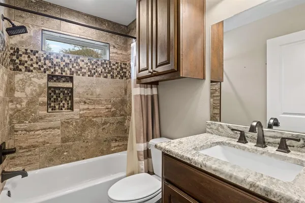 a bathroom with a granite countertop sink toilet and shower