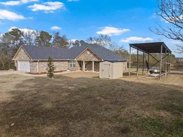 a view of a house with a yard and sitting area