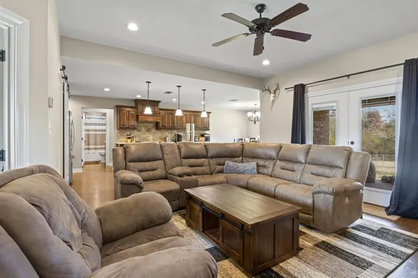 a living room with furniture and a ceiling fan