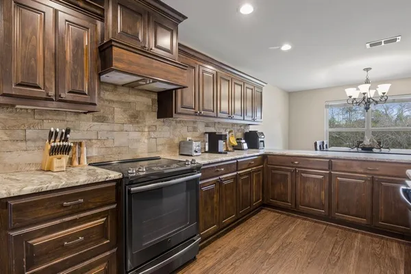 a kitchen with stainless steel appliances granite countertop wooden cabinets and a sink