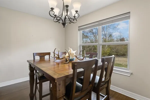 a view of a dining room with furniture a chandelier and wooden floor