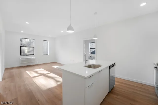 a kitchen with granite countertop a sink and dishwasher with wooden floor