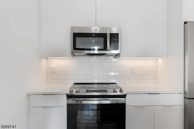 a kitchen with a refrigerator a sink and wooden floor