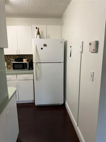 a white refrigerator freezer sitting inside of a kitchen