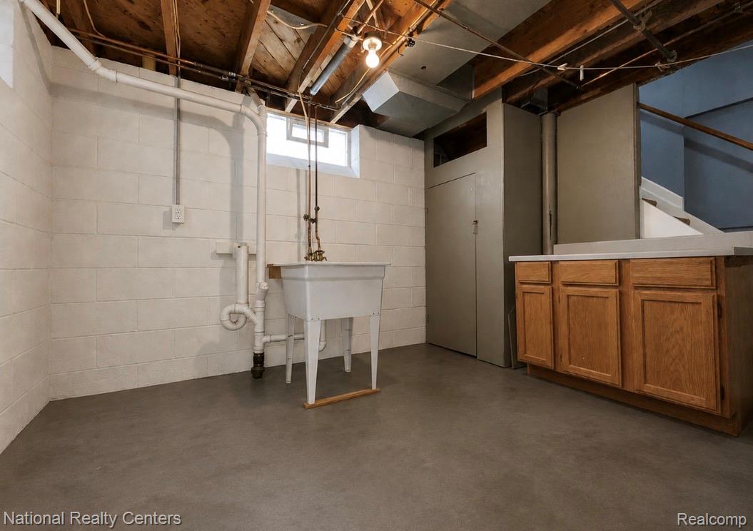 7285 Helen Street Center Line, MI 48015 - Photo 23 of 32 Unfinished basement with concrete flooring, exposed ceiling joists, and painted cinder block walls