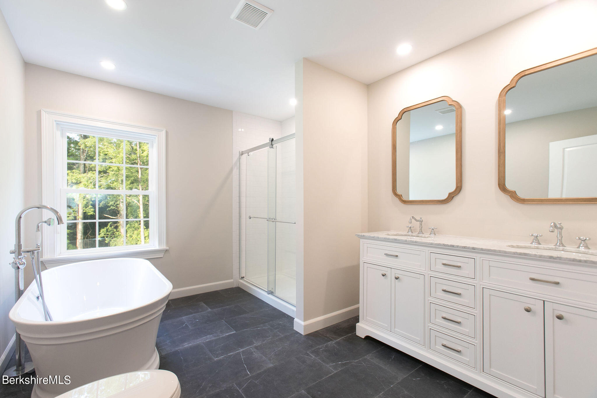 897 Canaan Valley Road New Marlborough, MA 01259 - Photo 30 of 50 a bathroom with double vanity sink a mirror a toilet and a window