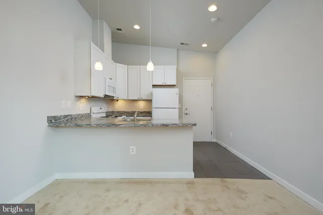 an empty room with wooden floor and cabinets