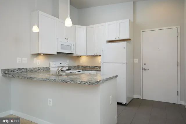 a kitchen with stainless steel appliances granite countertop refrigerator sink and cabinets