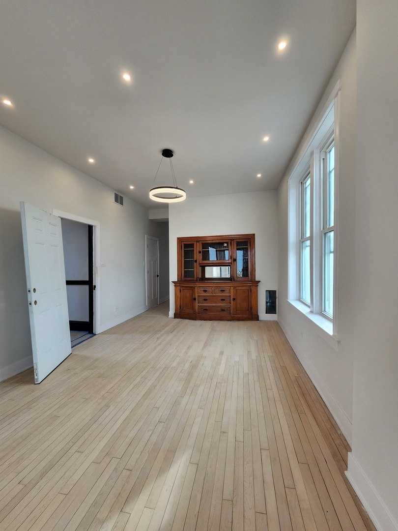 2345 West 23rd Street, Unit 3 Chicago, IL 60608 - Photo 3 of 7 a view of empty room with a fireplace and wooden floor