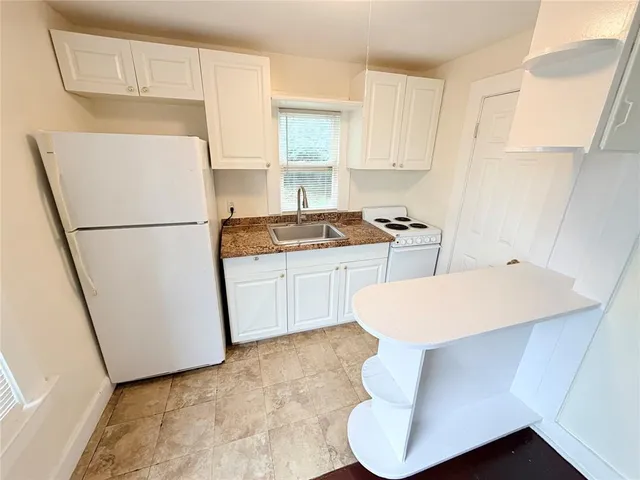 a white refrigerator freezer sitting inside of a kitchen