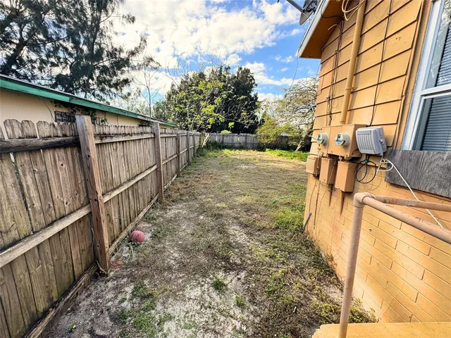 a view of a backyard with wooden fence