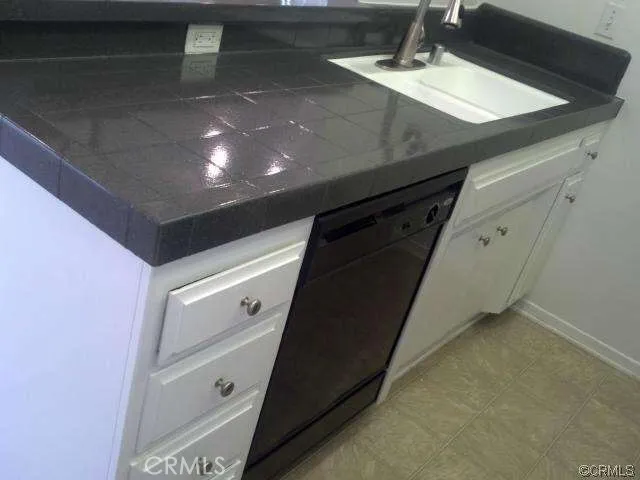 a kitchen with stainless steel appliances granite countertop white cabinets and black stove top