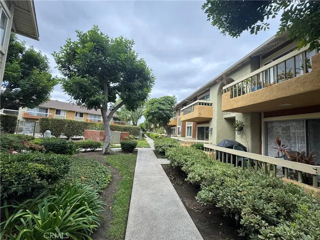 a view of a house with a small yard and potted plants