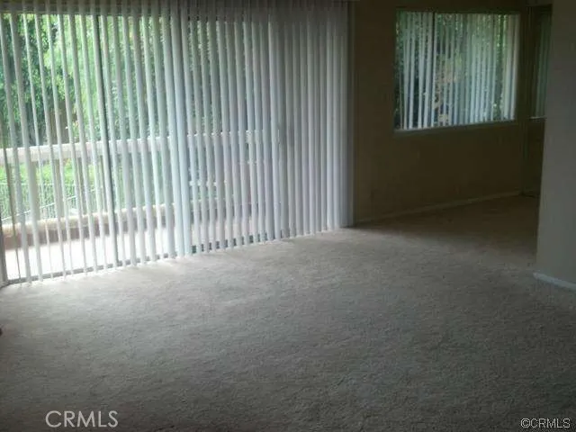 a view of a livingroom with an empty space and a window