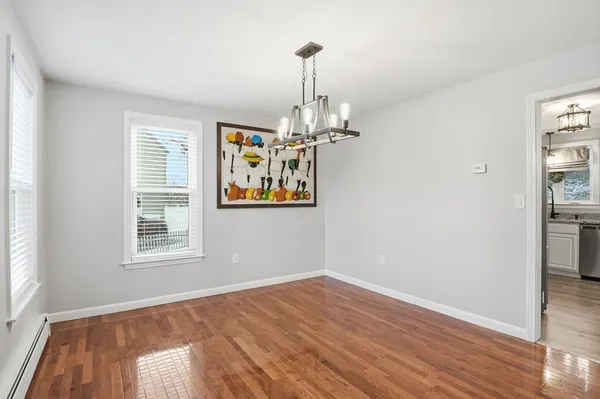 a view of empty room with wooden floor and window