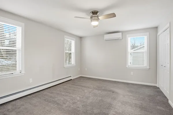 an empty room with windows and fan