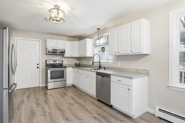 a kitchen with kitchen island white cabinets and stainless steel appliances