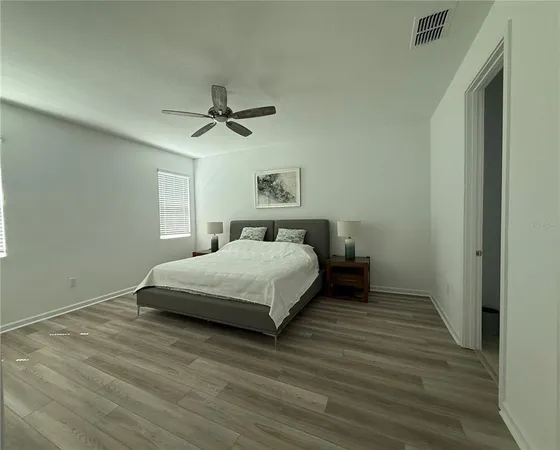 a bedroom with a bed and a ceiling fan
