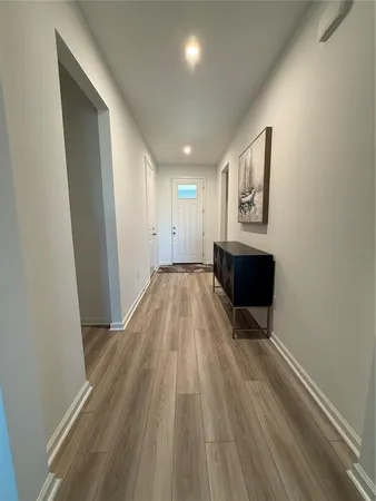 a view of a hallway with wooden floor and fireplace