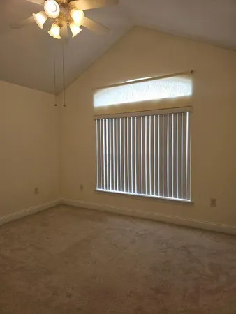 a view of an empty room with a chandelier fan