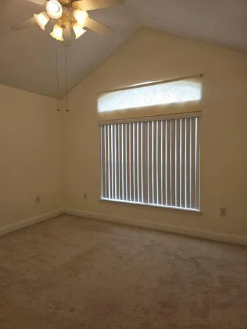 a view of an empty room with a chandelier fan